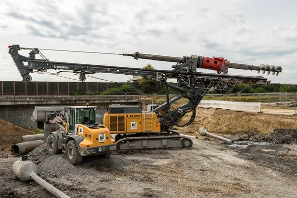 Taladro rotatorio grande y excavadora en el sitio de construcción — Foto de Stock