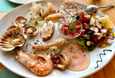 Lezzetli İtalyan deniz ürünleri ve ahşap restoran masasında aperatif olarak balık antipasti tabağı. Gurme yemekleri yakın çekim, aperatif, antipatik, deniz ürünleri tabağı
