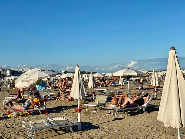 Niezidentyfikowani ludzie późnym popołudniem na plaży Caorle w Veneto, Włochy — Zdjęcie stockowe