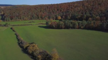 Sonbahar ormanının havadan görünüşü. Güney Almanya 'da Stuttgart yakınlarında güneşli bir Ekim gününde kırmızı, sarı ve yeşil yapraklarla sonbahar manzarası