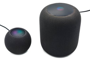 Yeni siyah Apple Homepod Mini beyaz arka planda siyah bir Apple Homepod 'un yanında duruyor..