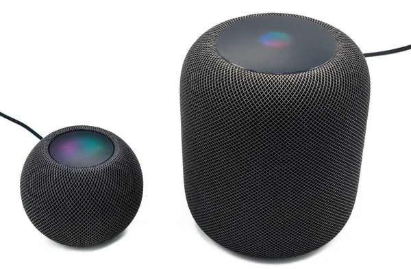 El nuevo Apple Homepod Mini negro está de pie junto a un altavoz inteligente Apple Homepod negro sobre un fondo blanco claro. —  Fotos de Stock