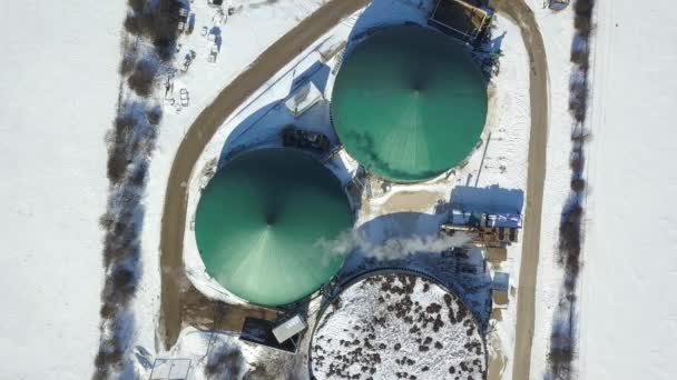Vue aérienne d'une usine de biogaz dans des champs enneigés produisant de l'énergie renouvelable à partir de biomasse dans le sud de l'Allemagne par une belle journée d'hiver — Video
