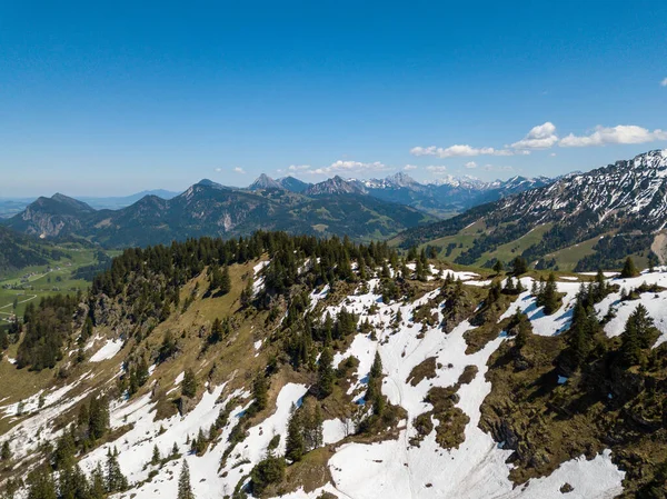 Widok z lotu ptaka na Alpy Allgau w Bawarii, Niemcy, w słoneczny majowy dzień z ostatnim śniegiem w wyższych górach — Zdjęcie stockowe