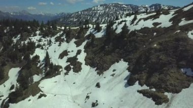 Mayıs ayının güneşli bir gününde Allgau Alpleri 'ndeki Oberjoch köyünün hava manzarası yüksek dağlardaki son karla birlikte