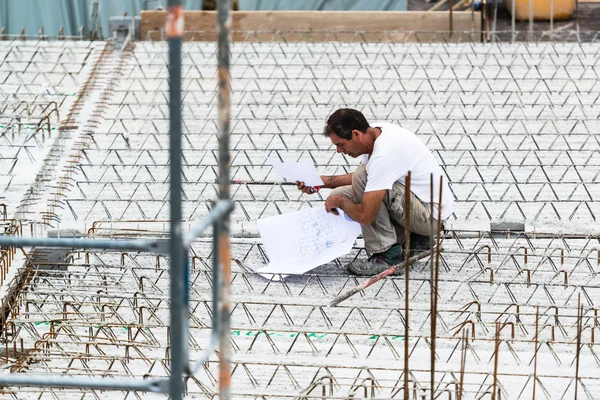 Eengineer τον έλεγχο σε ένα σχέδιο εργασίας για ένα εργοτάξιο — Φωτογραφία Αρχείου