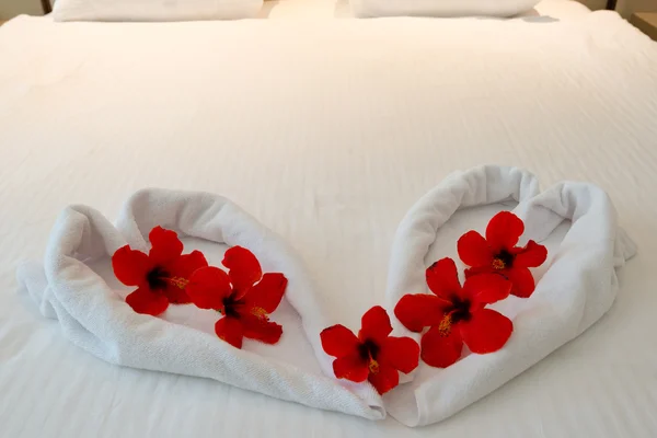 Hart gemaakt van handdoeken op huwelijksreis bed — Stockfoto