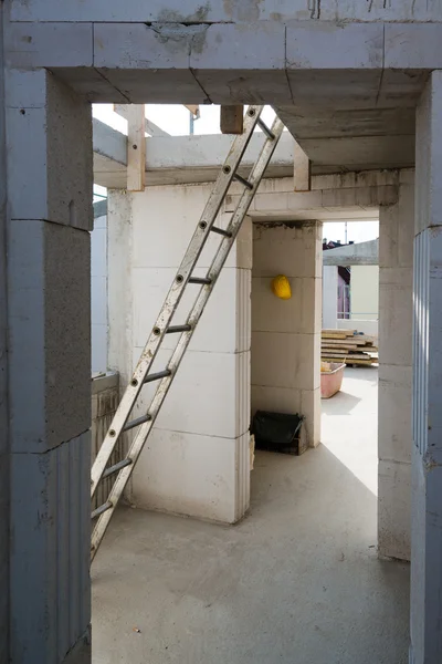 Лестница и каска в помещениях на стройплощадке — стоковое фото