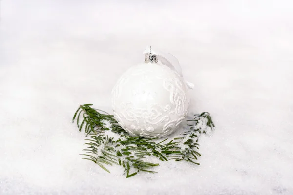 Bola de Navidad y rama de abeto con nieve — Foto de Stock