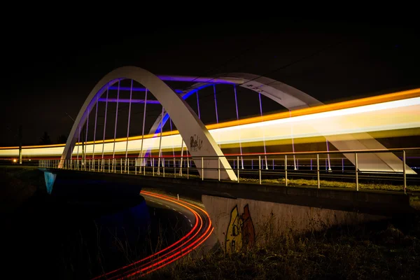 Puente ferroviario con luces de tren y coche por la noche —  Fotos de Stock