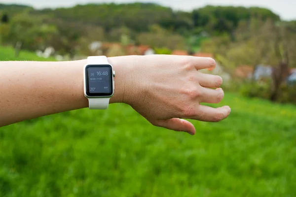 Woman checking her Apple Watch in the green — Stock Photo, Image