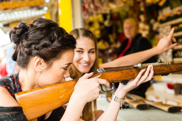 Two attractive girls playing shooting games at German funfair — Stock Photo, Image