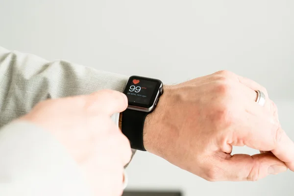 Zakenman controleren zijn pols met behulp van de Apple-Watch — Stockfoto