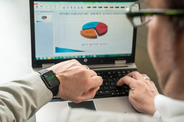 Zakenman aandelenkoersen op zijn horloge Apple controleren — Stockfoto