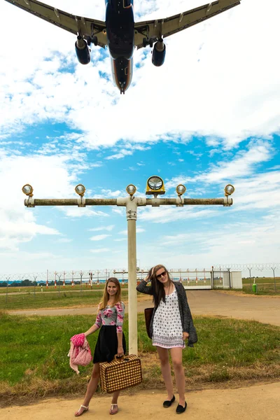 Two girls hitchhiking a plane — Stock Photo, Image