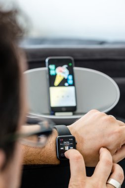 Apple müzik - bir adam, müzik arka planda bir hoparlör onun iphone ile Apple izle kullanarak onun oturma odasında kontrol ediyor