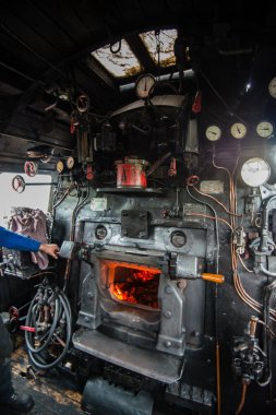 inside the cab of a classic steam locomotive with open fire clipart