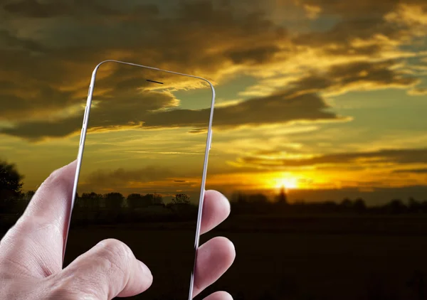 Smartphone med bild på solnedgången — Stockfoto
