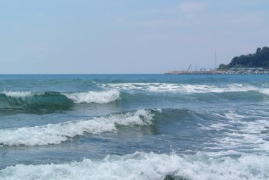 Azgın deniz mavi gökyüzü altında