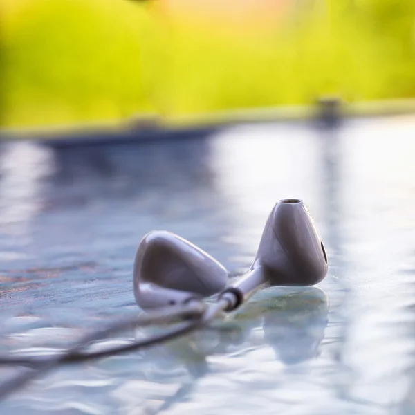 Auricolare bianco su tavolo di vetro — Foto Stock