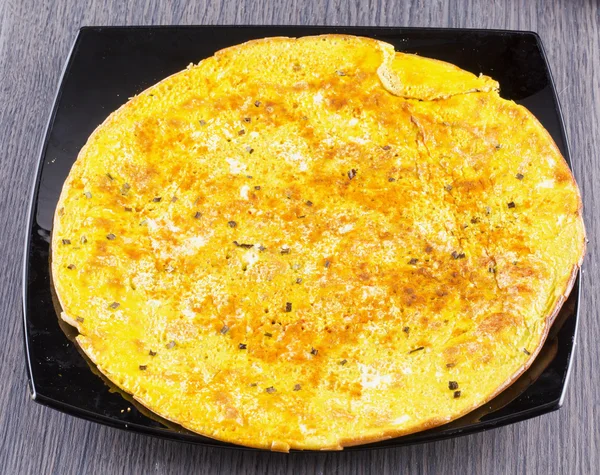 Omelette over black plate — Stock Photo, Image