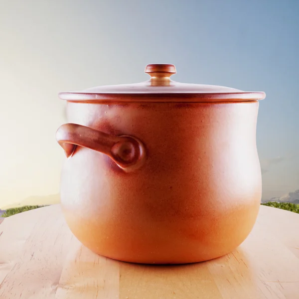 Big clay pot over wooden surface, blue sky on the background, square image — Stock Photo, Image