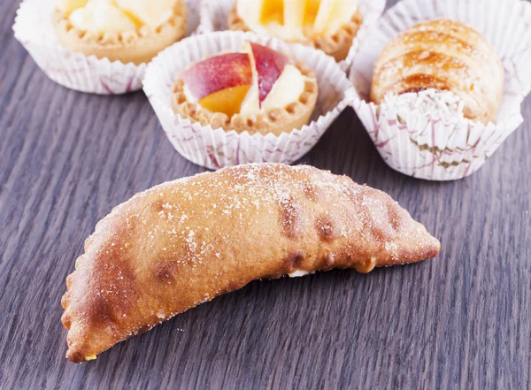 Pastries over wooden table — Stock Photo, Image