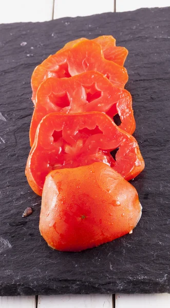 Tomatoes over black stone — Stock Photo, Image