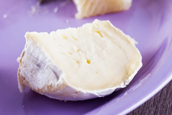 Queso brie sobre plato morado —  Fotos de Stock