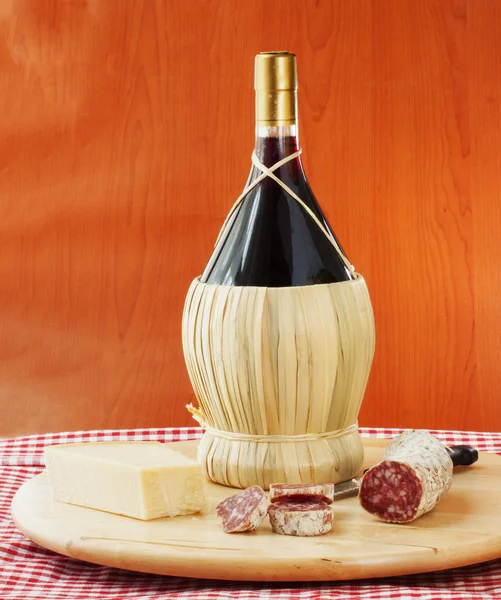 Frasco de vinho tinto com queijo e salsicha — Fotografia de Stock