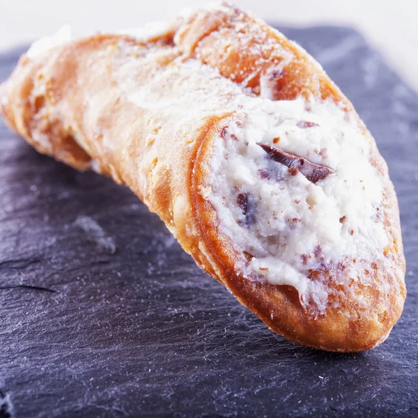 검은 돌 위에 Cannolo — 스톡 사진