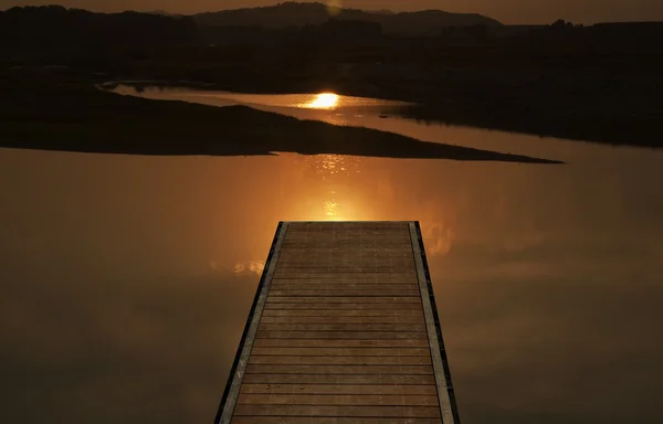 Muelle sobre la hermosa puesta de sol en el río —  Fotos de Stock