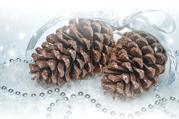 Dos conos de pino marrón brillante con guirnaldas y cinta decorada fo —  Fotos de Stock