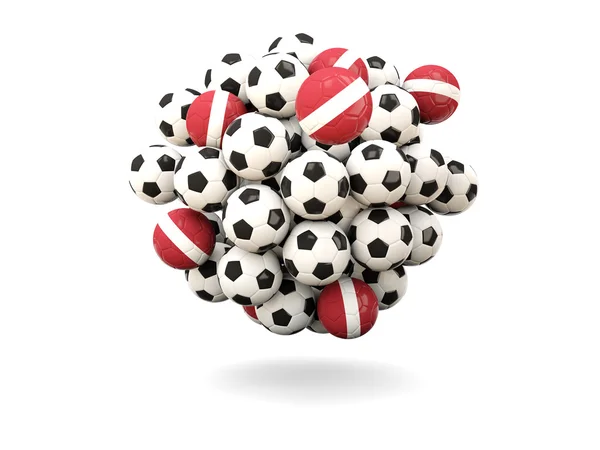 Pile de ballons de football avec drapeau de latvia — Photo