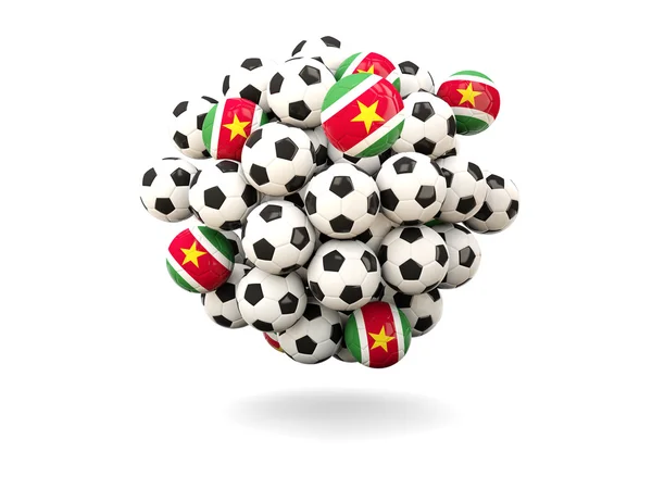 Pilha de bolas de futebol com bandeira do suriname — Fotografia de Stock