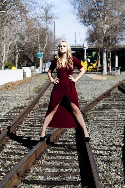Loira caucasiana mulher de pé em trilhas ferroviárias no vestido — Fotografia de Stock