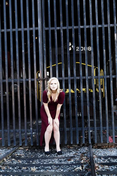 Mulher loira vestido vermelho ao ar livre trilhas ferroviárias — Fotografia de Stock