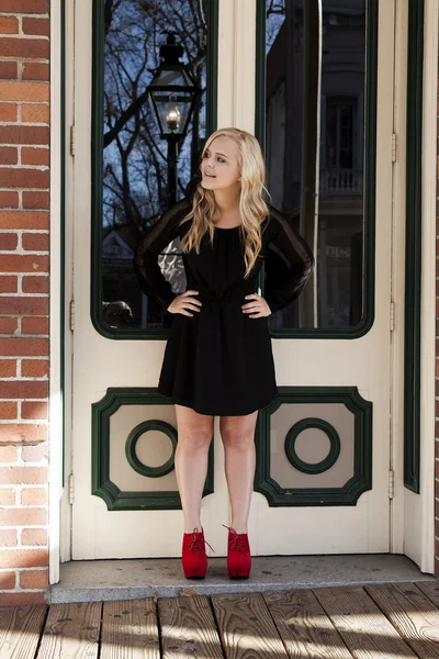 Atraente jovem loira de pé vestido preto sapatos vermelhos — Fotografia de Stock