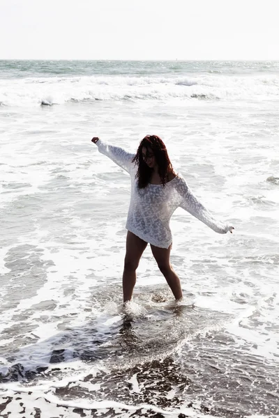 Latina vrouw lopen In oceaanwater op strand wit brei bekleding — Stockfoto