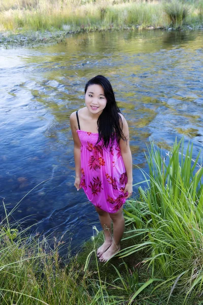 Молодий японський жінку, що стоїть на березі річки — стокове фото