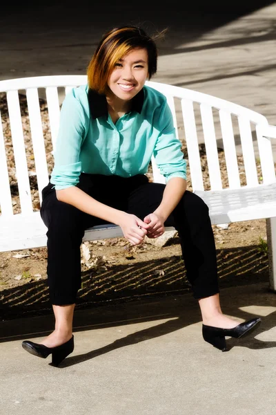 ベンチに座って笑顔の魅力的なアジア系アメリカ人女性 — ストック写真