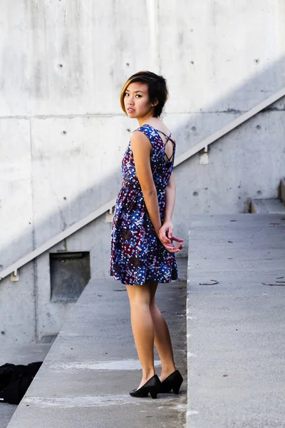 Ásia americano mulher no floral vestido olhando sobre ombro — Fotografia de Stock