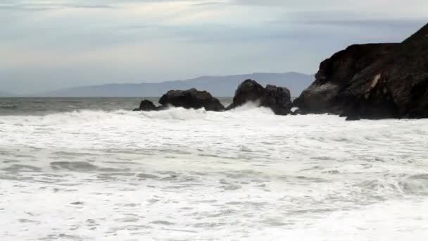 Moderado amplio tiro de olas golpeando cabecera Rocas — Vídeos de Stock