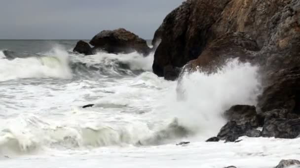 Onde moderate di colpo stretto schiantarsi in promontori rocciosi — Video Stock