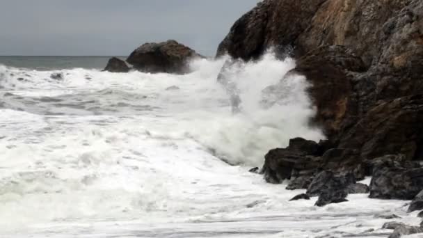 Onde moderate di colpo stretto schiantarsi in promontori rocciosi — Video Stock