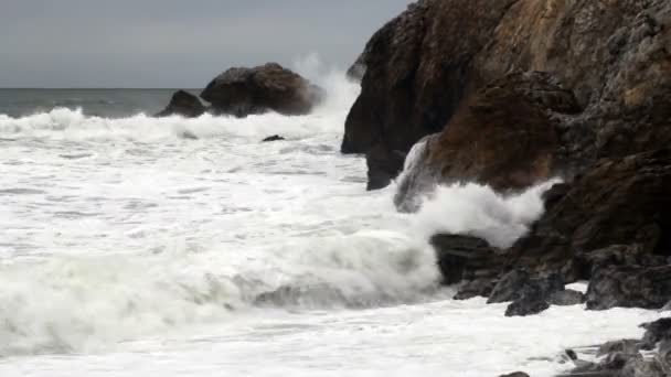 Szoros lövés közepes hullámok összeomlik a sziklás kikötő — Stock videók