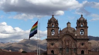 Plaza ile kilise arka planda uçan Cusco bayrak