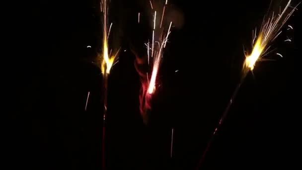 Three Sparklers Burning Together Against Dark Background — Stock Video
