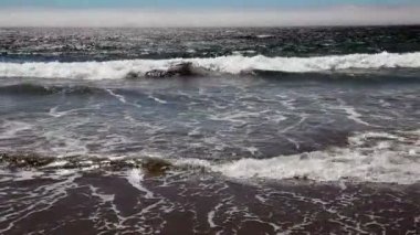 Çamaşır çerçeveyi dolduran sahilde dalgalar