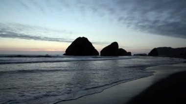 Twilight plaj dalgalar ve Off Shore kayalar